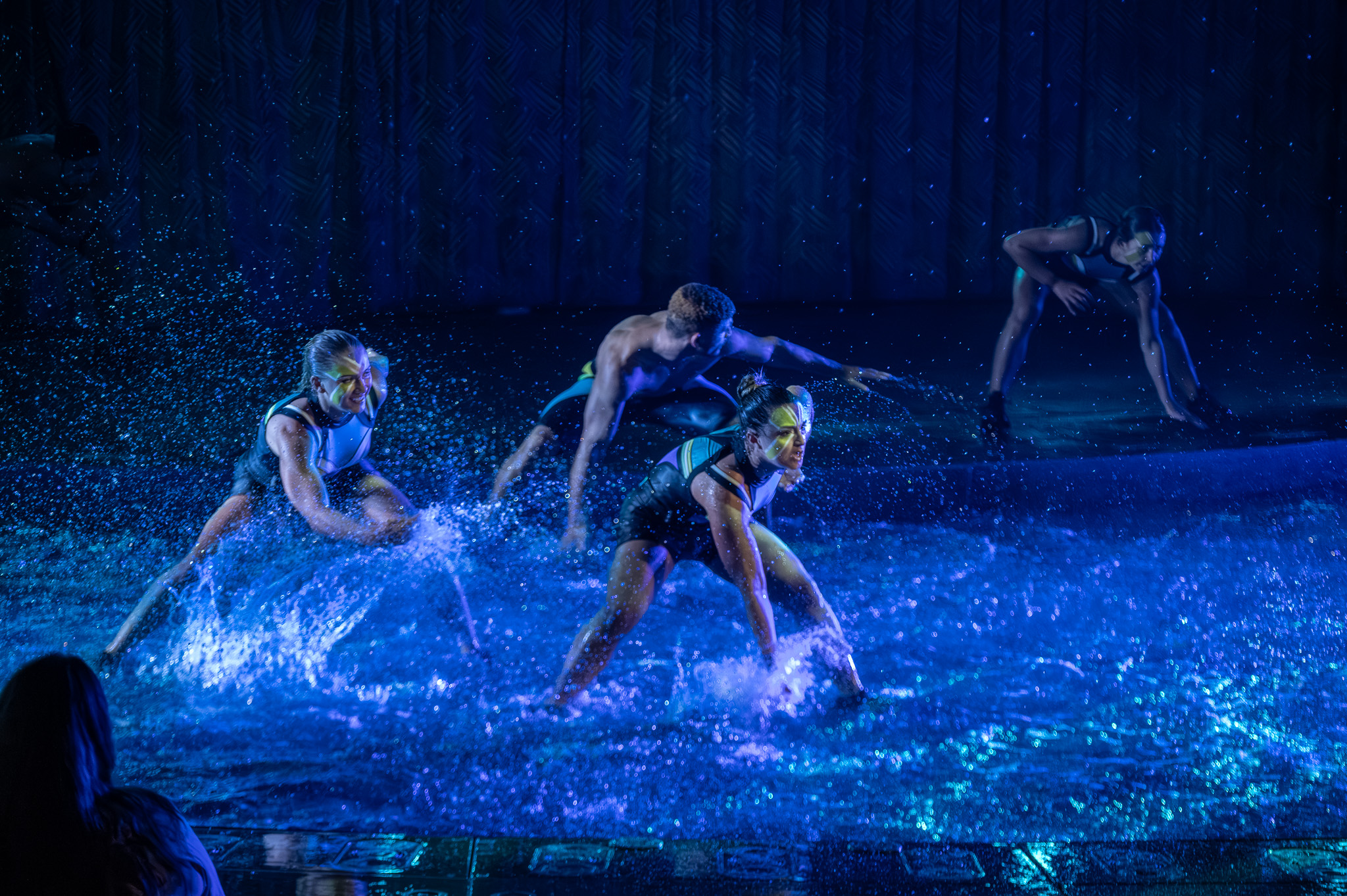 Performer surfing through a burst of water